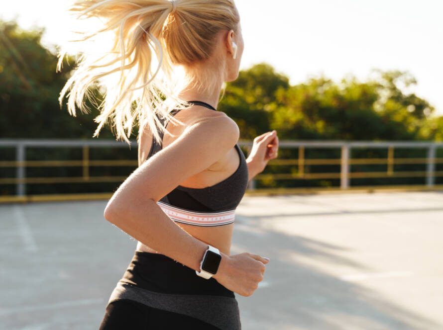 Image of attractive fitness woman wearing tracksuit running outdoors